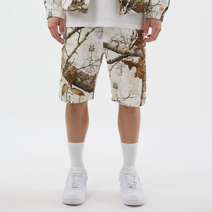 The Male model is wearing  New Era Earthy Skin Real Tree Snow Oversized Shorts 1