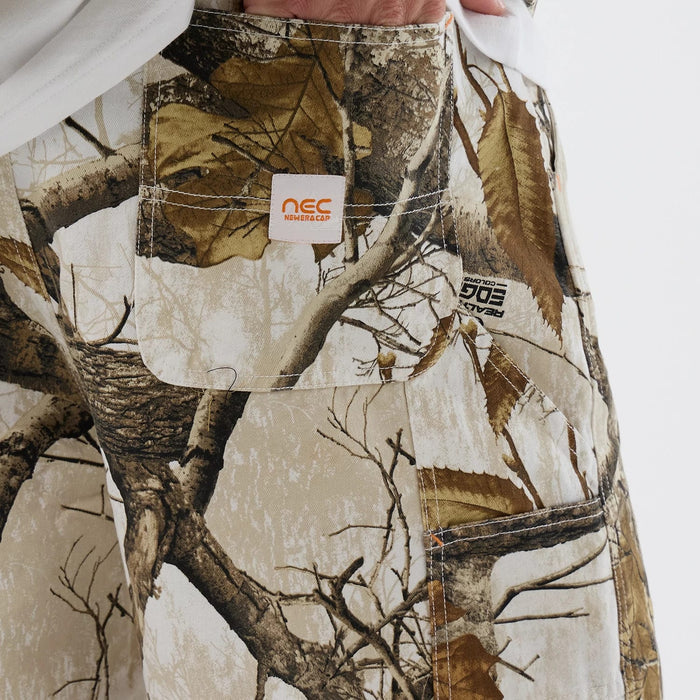 The Male model is wearing  New Era Earthy Skin Real Tree Snow Oversized Shorts 3